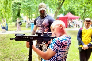 Policjanci i pracownicy OPS podczas pikniku rodzinnego zabawiają mieszańców miasta