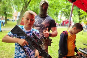 Policjanci i pracownicy OPS podczas pikniku rodzinnego zabawiają mieszańców miasta