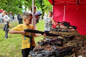 Policjanci i pracownicy OPS podczas pikniku rodzinnego zabawiają mieszańców miasta