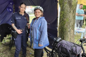 Policjanci i pracownicy OPS podczas pikniku rodzinnego zabawiają mieszańców miasta