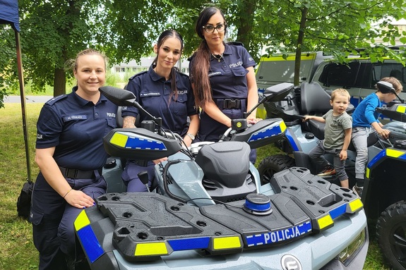 Policjanci i pracownicy OPS podczas pikniku rodzinnego zabawiają mieszańców miasta