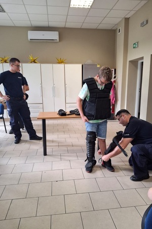 Policjanci prowadzą spotkanie edukacyjne z półkolonistami