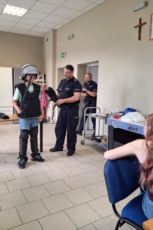 Policjanci prowadzą spotkanie edukacyjne z półkolonistami