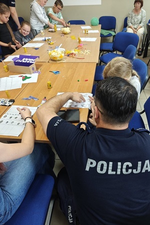 Policjanci prowadzą spotkanie edukacyjne z półkolonistami
