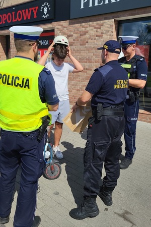 Działania policjantów ruchu drogowego, którzy rozdawali kaski użytkownikom hulajnóg elektrycznych