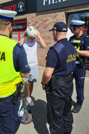 Działania policjantów ruchu drogowego, którzy rozdawali kaski użytkownikom hulajnóg elektrycznych