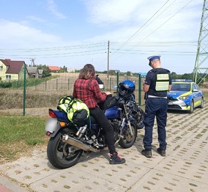 Policjant kontroluje motocyklistę
