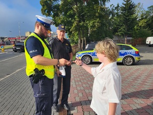 Policjanci i strażnicy miejscy podczas działań przy szkołach rozdają odblaski