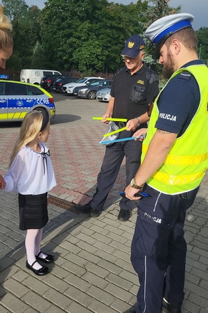 Policjanci i strażnicy miejscy podczas działań przy szkołach rozdają odblaski