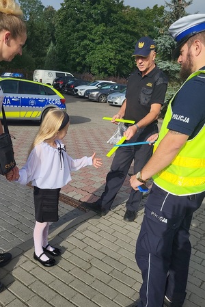 Policjanci i strażnicy miejscy podczas działań przy szkołach rozdają odblaski