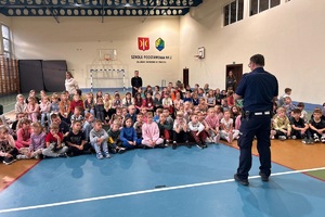 Policjant ruchu drogowego prowadzi z uczniami spotkanie
