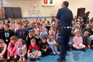 Policjant ruchu drogowego prowadzi z uczniami spotkanie