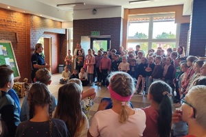 Policjantka na korytarzu szkolnym rozmawia z uczniami i prowadzi pogadankę