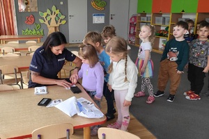 Policjantka wykonuje dzieciom pamiątkowe kartki z odbitkami ich linii papilarnych