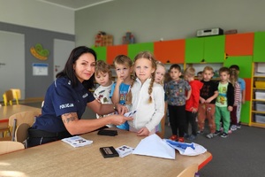 Policjantka wykonuje dzieciom pamiątkowe kartki z odbitkami ich linii papilarnych