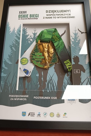 Kierownik posterunku otrzymuje podziękowania i pozuje do zdjęcia z otrzymanym medalem pamiątkowym
