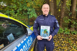 Kierownik posterunku otrzymuje podziękowania i pozuje do zdjęcia z otrzymanym medalem pamiątkowym