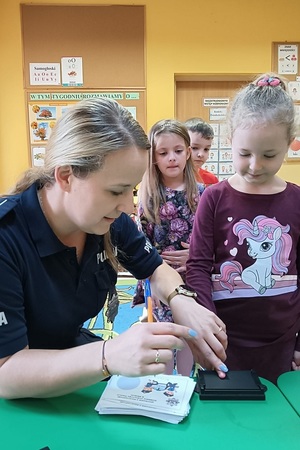 Policjanci prowadza zajęcia z przedszkolakami i opowiadają o bezpieczeństwie