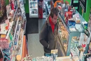 Wizerunek mężczyzny, który stoi przy kasie sklepowej