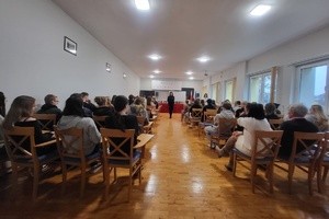 Policjantka stoi przed uczniami, prowadzi pogadankę