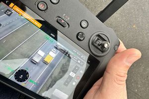 Policjant kontrolujący kierowcę ciężarówki i obserwujący ruch pojazdów dronem