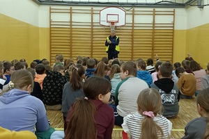 Policjant prowadzi pogadankę i praktyczną lekcję przechodzenia przez jezdnię