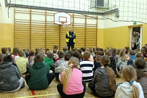 Policjant prowadzi pogadankę i praktyczną lekcję przechodzenia przez jezdnię