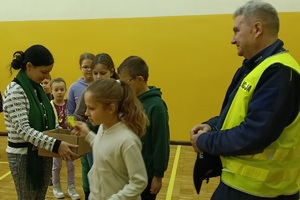 Policjant prowadzi pogadankę i praktyczną lekcję przechodzenia przez jezdnię