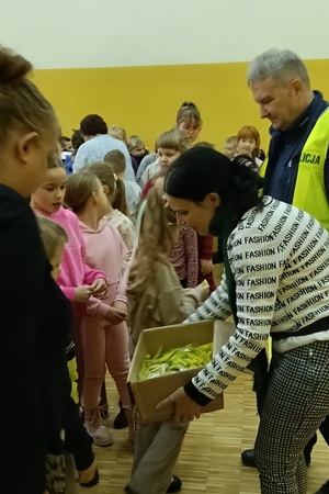 Policjant prowadzi pogadankę i praktyczną lekcję przechodzenia przez jezdnię