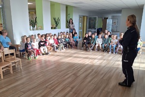 Policjanci prowadzą spotkanie z przedszkolakami, pokazują sprzęt służbowy i opowiadają o bezpieczeństwie