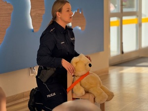 Policjanci prowadzą spotkanie z przedszkolakami, pokazują sprzęt służbowy i opowiadają o bezpieczeństwie