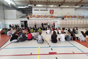 Dzieci siedzące na sali i słuchające pogadanki policjantki