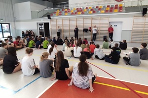 Dzieci siedzące na sali i słuchające pogadanki policjantki