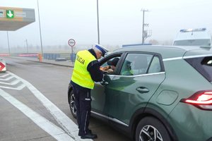 Funkcjonariusz ruchu drogowego kontroluje trzeźwość kierującego samochodem osobowym