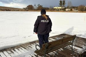 Policjantka sprawdza rejon przy akwenie wodnym