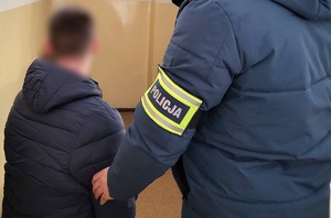 Policjant z zatrzymanym poszukiwanym listem gończym