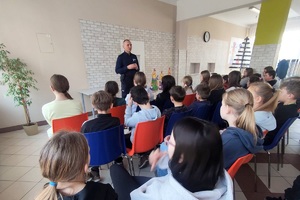 Policjant omawia zasady bezpiecznego poruszania się po drogach