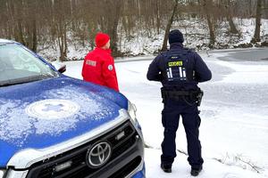 Ratownik WOPR i policjant przy pojeździe służbowym WOPR-u