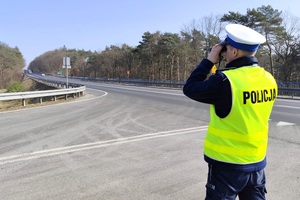 Policjant obserwuje pojazdy pod kątem ujawnienia wykroczeń
