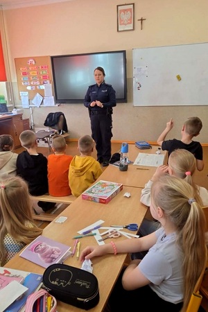 Policjantki rozmawiają z dziećmi i uczniami szkoły podczas spotkania profilaktycznego