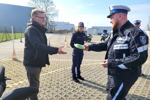 Funkcjonariusz przekazują elementy odblaskowe