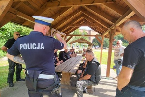 Policjant omawia zasady ruchu drogowego z motocyklistami