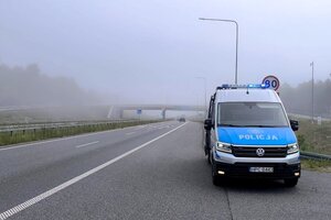 Radiowóz stoi na drodze, w tle widać mgłę