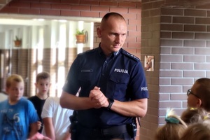 Policjant rozmawia z uczniami na temat " Bezpiecznej drogi do szkoły"