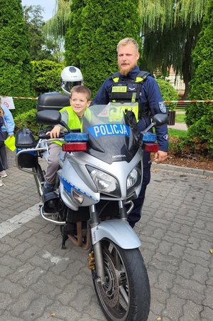 Uczniowie oglądają radiowozy i motor policyjny