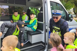 Uczniowie oglądają radiowozy i motor policyjny