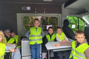 Uczniowie oglądają radiowozy i motor policyjny